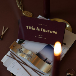 Incense packaging with lit incense stick on a dark surface