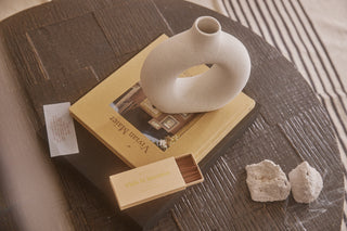coffee table with books, vase and incense