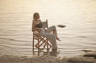 girl sitting on chair in lake at sunset